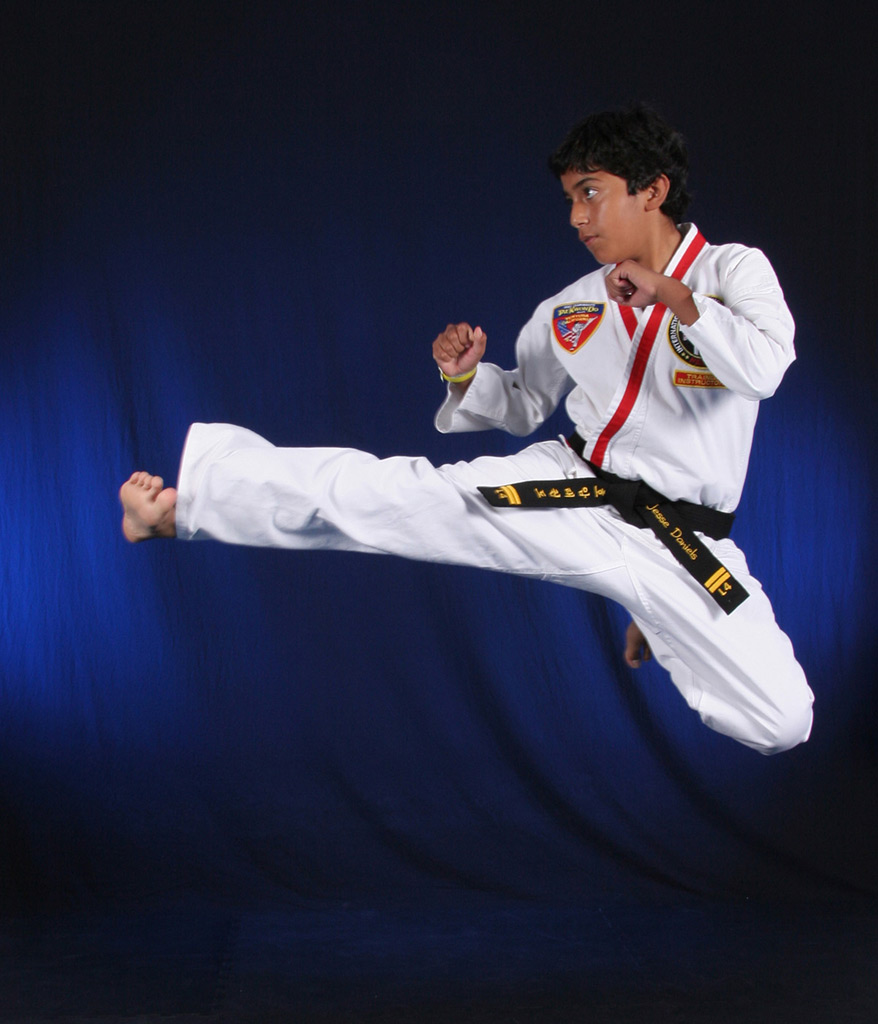Junior black belt demonstrating a flying side kick