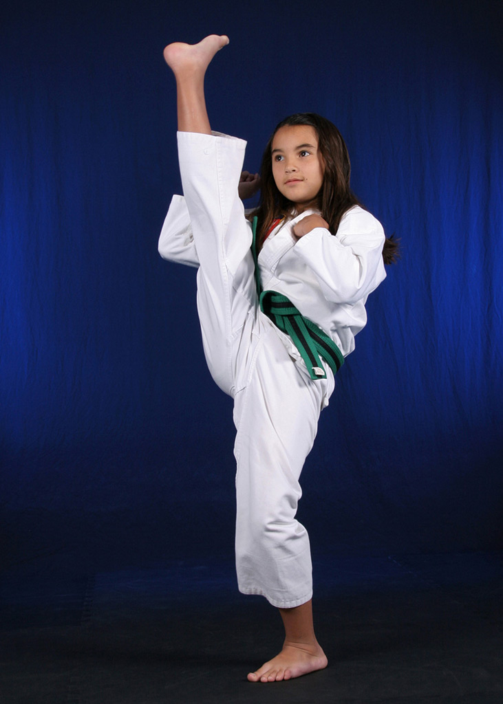 Junior green belt practicing a head high front kick